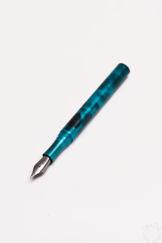 Teal anodized aluminum fountain pen with exposed nib, pocket-size design