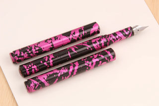 Set of three pink fountain pens with black graphic speckle pattern and metal nibs