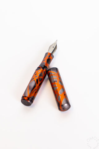 Orange and dark marbled fountain pen pair with pointed metal nibs