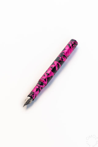 Pink fountain pen with black graphic splatter and pointed metal nib