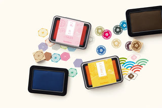 Assorted stamp ink pads with colored lids and bases arranged in a set