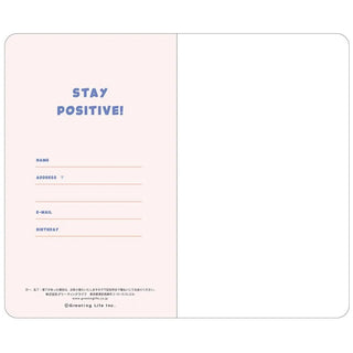 A6 slim diary open to info page with pink left panel and blue “STAY POSITIVE!” text