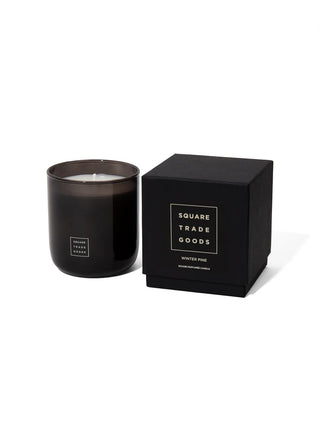 Black 10oz candle in glass jar with white label, with black Square Trade Goods box
