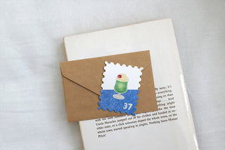Brown envelope with a postage-stamp sticker and a letter page underneath