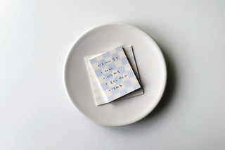 Pastel checkered sticky notes with lavender memo tabs on a dish