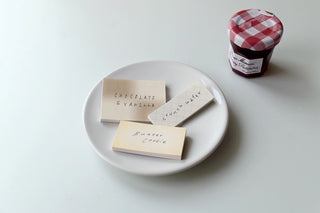 Chocolate-and-vanilla style sticky memo notes on plate, with small checkered container