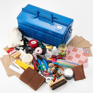 Blue cantilever toolbox open on top of mixed tools and accessories.
