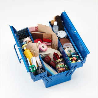 Blue cantilever toolbox open with compartments filled with tools and supplies.