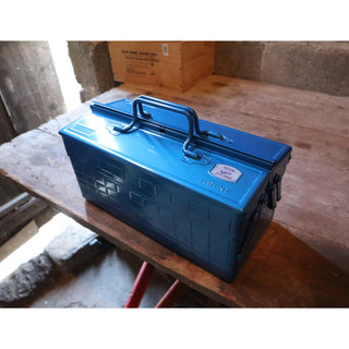 Blue cantilever toolbox closed with top handle on a wooden work surface.