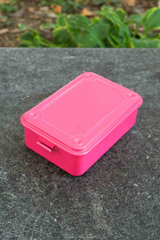 Shocking pink trunk-shaped toolbox with hinged lid, top view