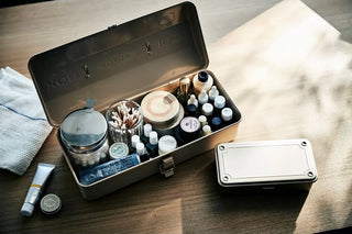 Beige tool box open showing storage compartments with bottles and tools inside