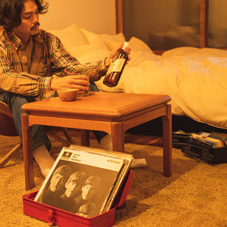 Red toolbox opened on the floor, holding a vinyl record sleeve.