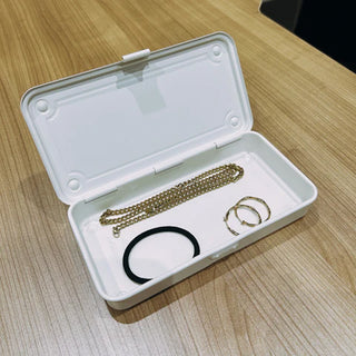 White trunk toolbox case open with chain and rings in the tray