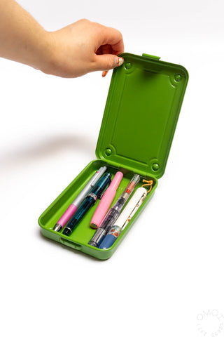 Matcha green trunk-shaped toolbox opened with pens in molded slots
