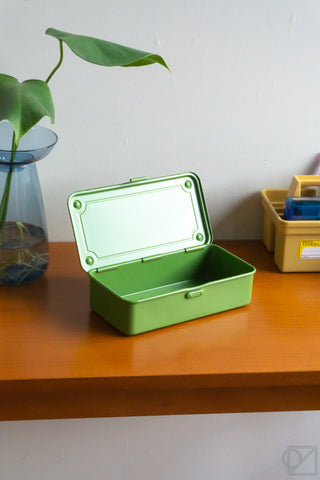 Green stackable storage box with lid open and empty interior on tabletop