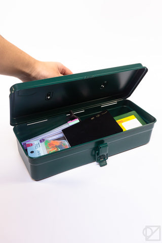 Antique green trunk-shaped toolbox opened with latch, showing items inside