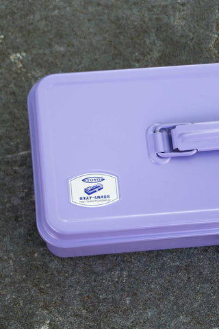 Lilac toolbox close-up with logo badge and metal latch on lid