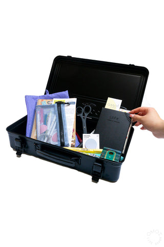 Black trunk toolbox open with organizer accessories and hand reaching inside