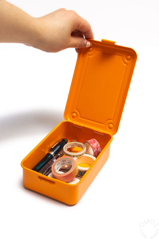 Orange trunk-shape toolbox open, showing assorted small tools and supplies inside