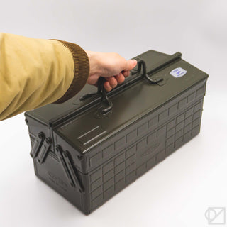 Olive green cantilever toolbox held by handle, with side latches