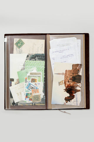Traveler's notebook zipper case open, holding documents and stamps inside