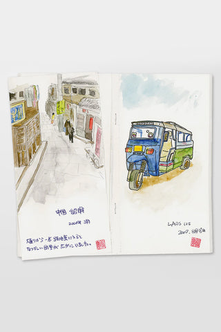 Open sketch notebook with watercolor street scene and bus illustration