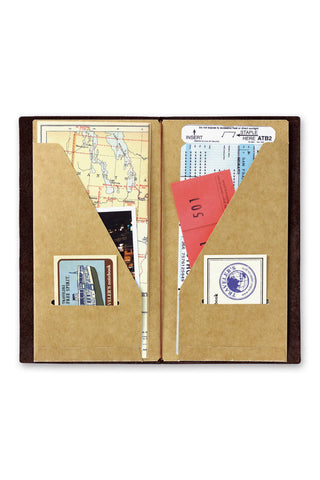 Kraft paper notebook folder open, showing photo and stamp inserts in inner sleeves