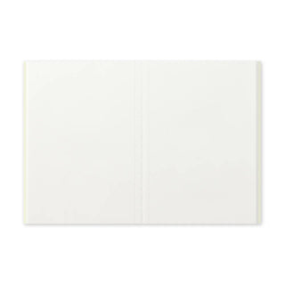 Passport-size notebook opened flat, cream pages with center binding