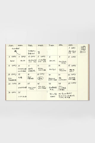 Traveler's notebook open monthly planner page with handwritten dates and notes