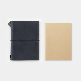 Kraft paper passport notebook next to a dark notebook, both closed with wrap band