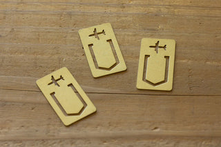 Three brass airplane clips with cutout airplane icons on yellow-gold backs