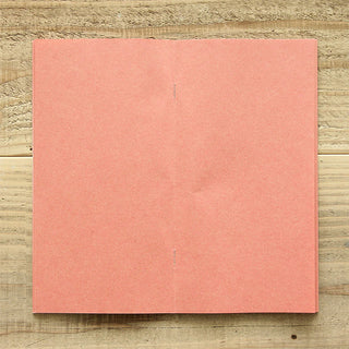 Pink kraft notebook refill cover shown flat on a wooden surface