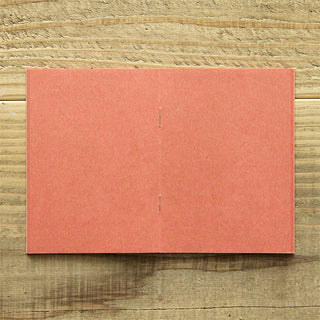 Pink kraft passport-size notebook, front cover laid flat