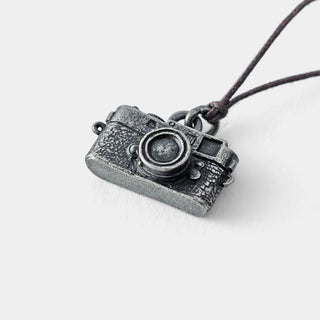 Pewter camera charm pendant with dark cord, front view