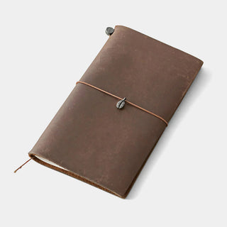 Pewter coffee bean charm secured to a brown leather notebook with cord