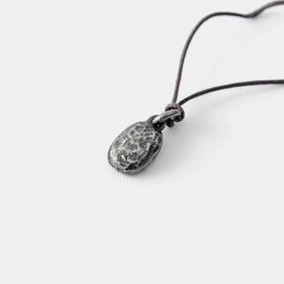 Detailed view of pewter coffee bean charm on black cord