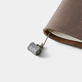 Pewter charm mug pendant with cord, small cylindrical shape with open top.