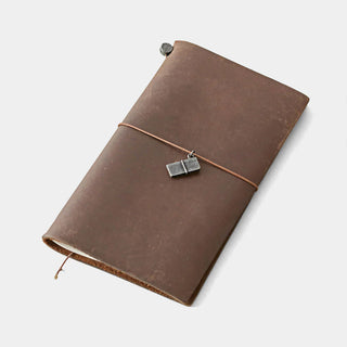 Pewter mini notebook charm hanging from cord on brown leather journal