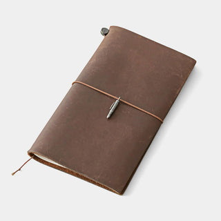 Pewter pen charm tied to a brown leather notebook with a dark string loop