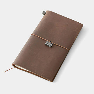 Pewter trunk charm tied around brown leather notebook cover