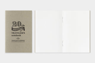 Opened 20th anniversary notebook with beige pages and stitched fold