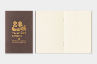 Opened 20th anniversary notebook with dark cover and beige insert pages
