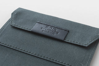 Dark fabric card cover with stitched flap and Traveler's logo tab