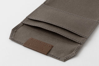 Card-size notebook inner flap with brown leather label and folded pocket