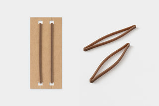 Brown leather notebook bands with white inner supports and two cord ties.