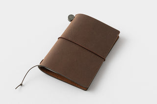 Brown card-size notebook cover lying flat, with tied string and round button