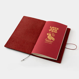 Open red leather journal with LOVE AND TRIP cover page and attached string