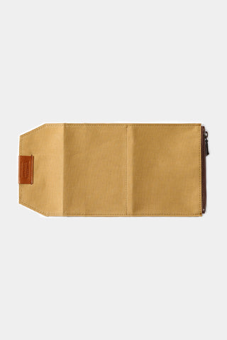 Beige passport-size cotton zipper case, side profile with metal zipper pull, closed.