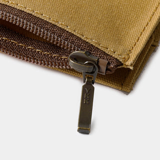 Close-up of beige cotton zipper case with metal zipper pull and stitched fabric edge.