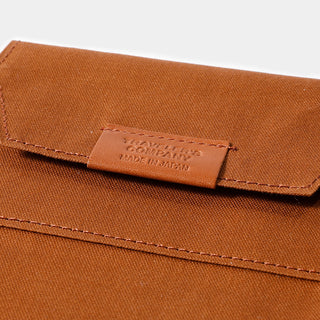 Brown cotton zipper case corner label with stitched edge and brand mark
